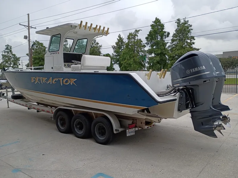 Slide: The Image of Custom 32CC 2005 boat named "Extractor" on trailer with Yamaha engines. - 4