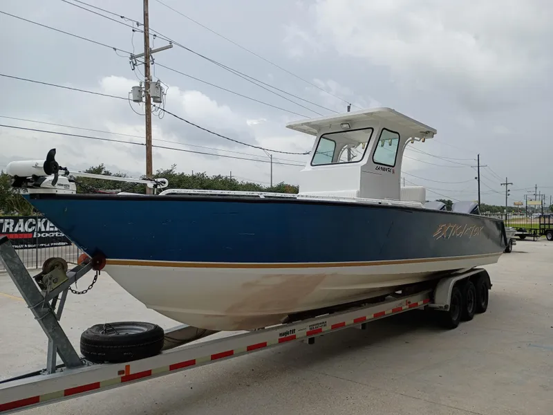 Slide: The Image of 2005 Custom 32CC boat on trailer, blue hull, parked outdoors. - 5