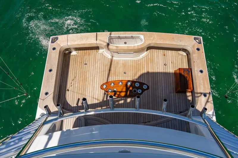 Slide: The Image of 2023 Hatteras GT45X yacht deck with fishing setup, surrounded by ocean water. - 12