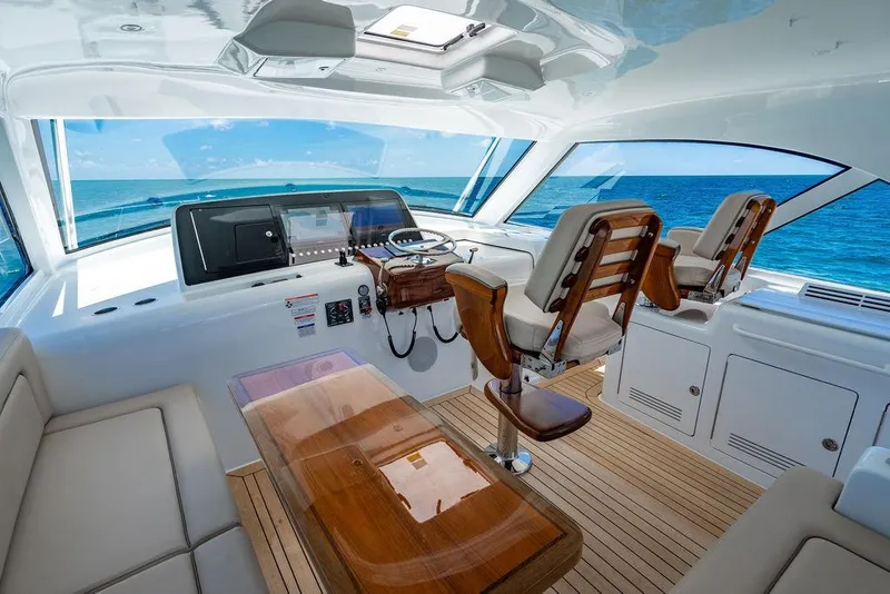 Slide: The Image of Luxurious 2023 Hatteras GT45X yacht interior with ocean view, featuring elegant seating and helm. - 15