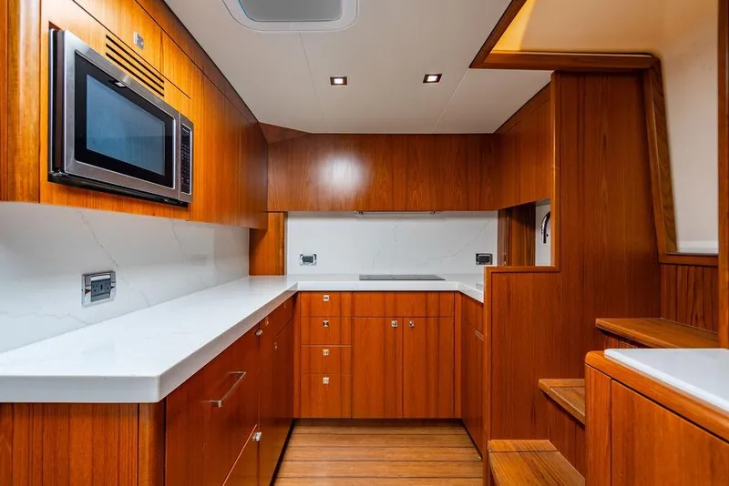 Slide: The Image of Luxurious 2023 Hatteras GT45X yacht interior with modern kitchen and wooden cabinetry. - 19