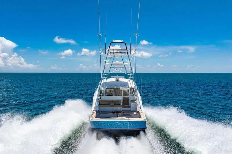 Slide: The Image of 2023 Hatteras GT45X yacht cruising on open ocean under clear blue sky. - 2