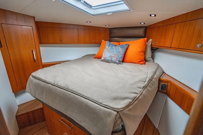Slide: The Image of Luxurious cabin interior of 2023 Hatteras GT45X yacht with cozy bedding and wooden cabinetry. - 24