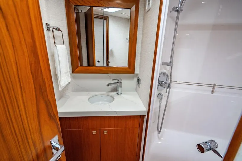 Slide: The Image of Luxurious bathroom in 2023 Hatteras GT45X yacht with modern fixtures and wooden accents. - 28