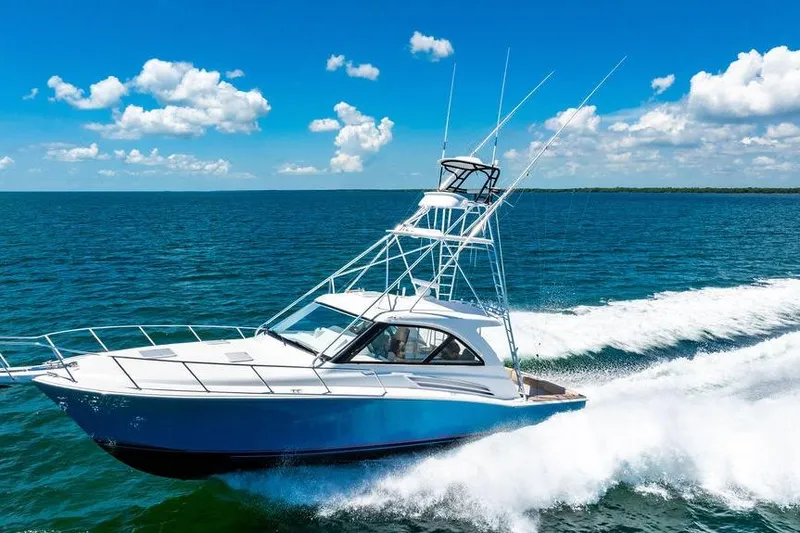Slide: The Image of 2023 Hatteras GT45X yacht cruising on open sea under clear blue sky. - 3