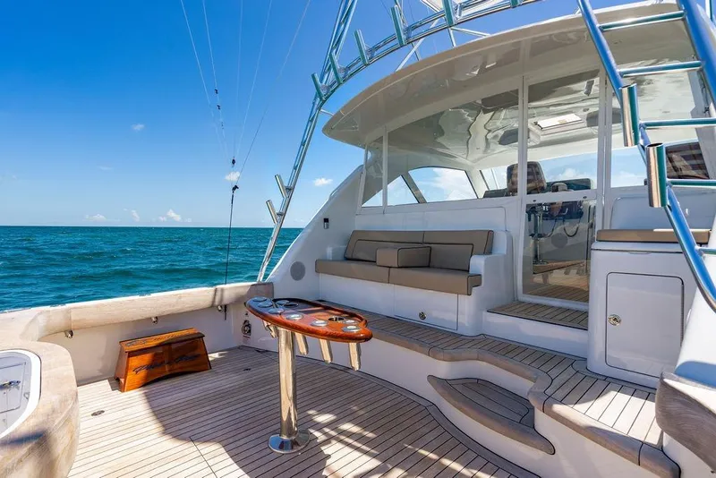 Slide: The Image of 2023 Hatteras GT45X yacht deck with seating, table, and ocean view. - 6