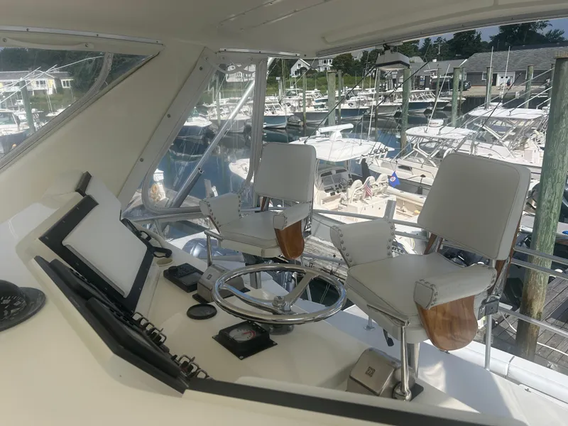 Slide: The Image of Interior helm of 1990 Bertram 50 Convertible yacht with marina view. - 10