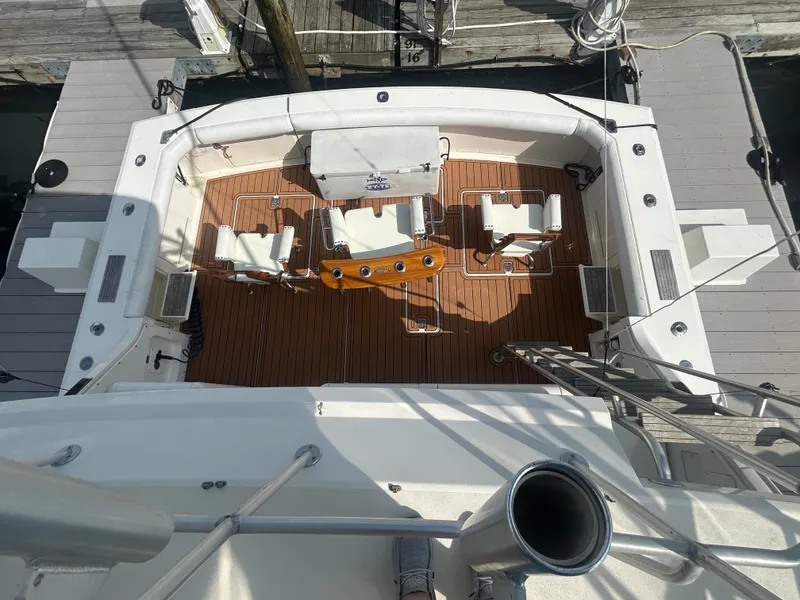 Slide: The Image of 1990 Bertram 50 Convertible yacht deck with seating and wooden flooring. - 13