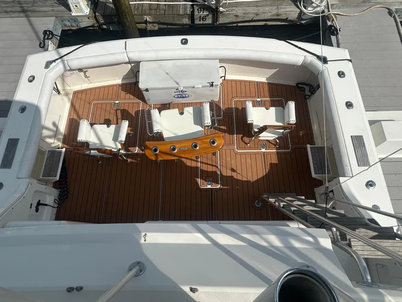 Slide: The Image of 1990 Bertram 50 Convertible yacht deck with seating and wooden flooring. - 14