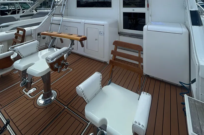 Slide: The Image of 1990 Bertram 50 Convertible yacht deck with fishing chairs and teak flooring. - 15