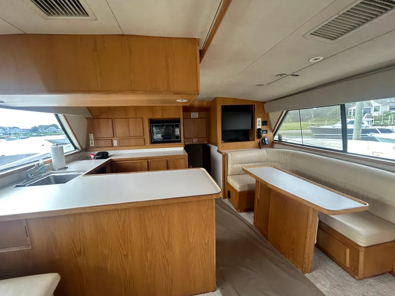 Slide: The Image of Interior of a 1990 Bertram 50 Convertible yacht with kitchen and seating area. - 17