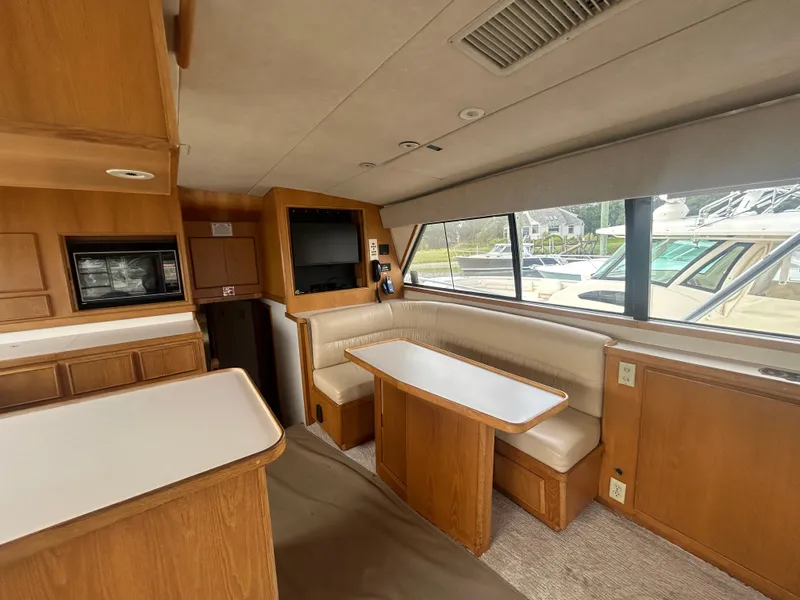 Slide: The Image of Interior of a 1990 Bertram 50 Convertible yacht with wood cabinetry and seating area. - 18