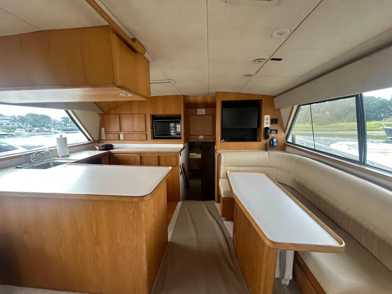 Slide: The Image of Interior of a 1990 Bertram 50 Convertible yacht with wood cabinetry and seating area. - 19