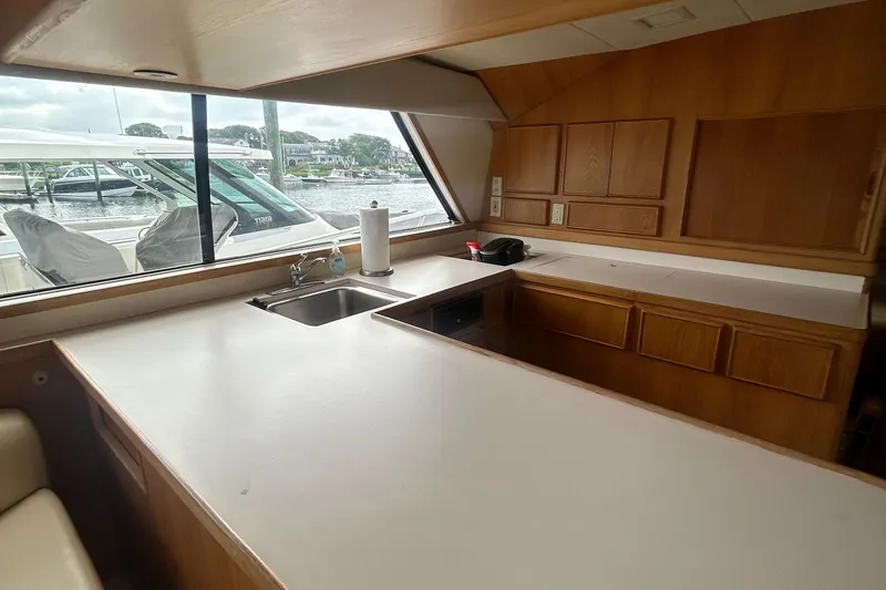 Slide: The Image of Interior of 1990 Bertram 50 Convertible yacht with wooden cabinetry and countertop. - 24