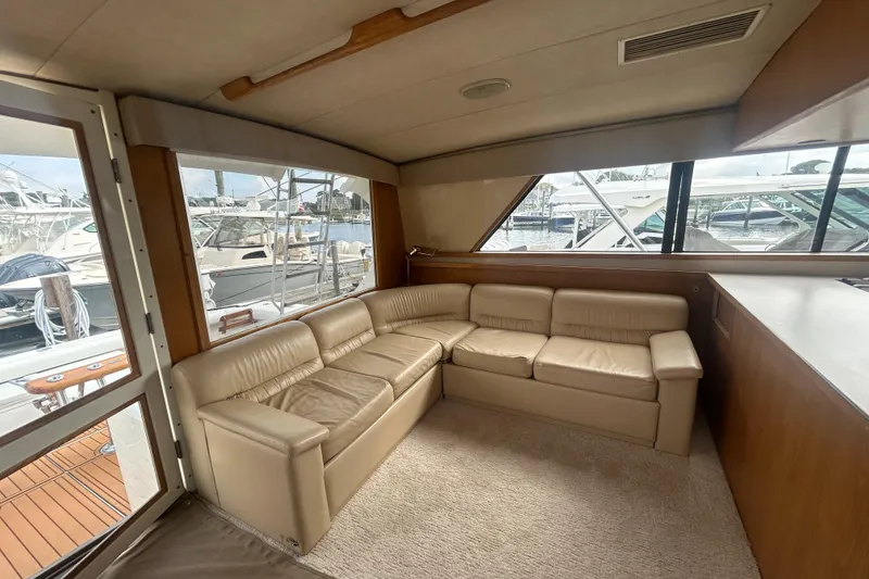 Slide: The Image of Interior of 1990 Bertram 50 Convertible yacht with beige leather seating and large windows. - 25