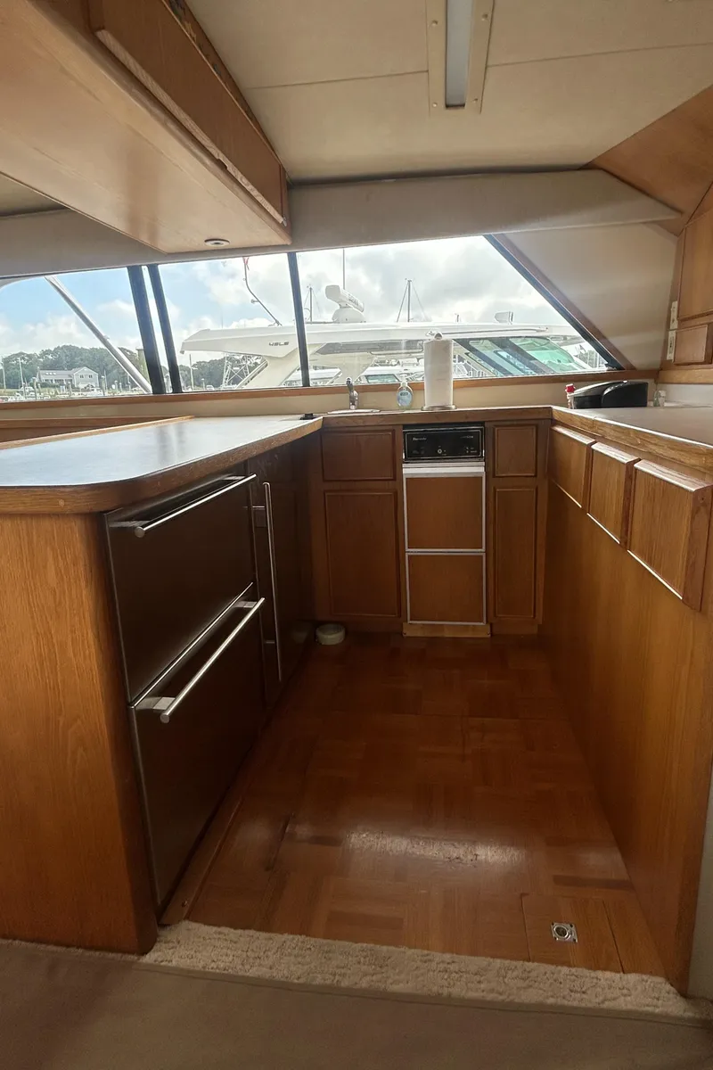 Slide: The Image of Interior of 1990 Bertram 50 Convertible yacht with wooden cabinetry and large windows. - 29