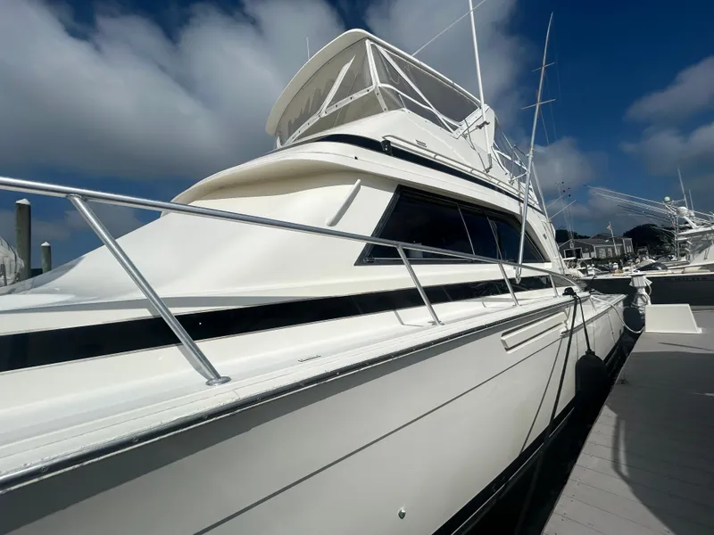 Slide: The Image of 1990 Bertram 50 Convertible yacht docked under a clear blue sky. - 3
