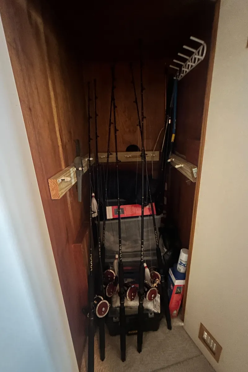 Slide: The Image of Fishing rods stored in a wooden compartment on a 1990 Bertram 50 Convertible boat. - 31