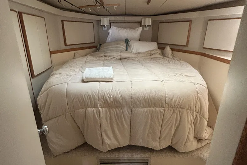 Slide: The Image of Cozy bedroom in 1990 Bertram 50 Convertible yacht with plush bedding and soft lighting. - 34