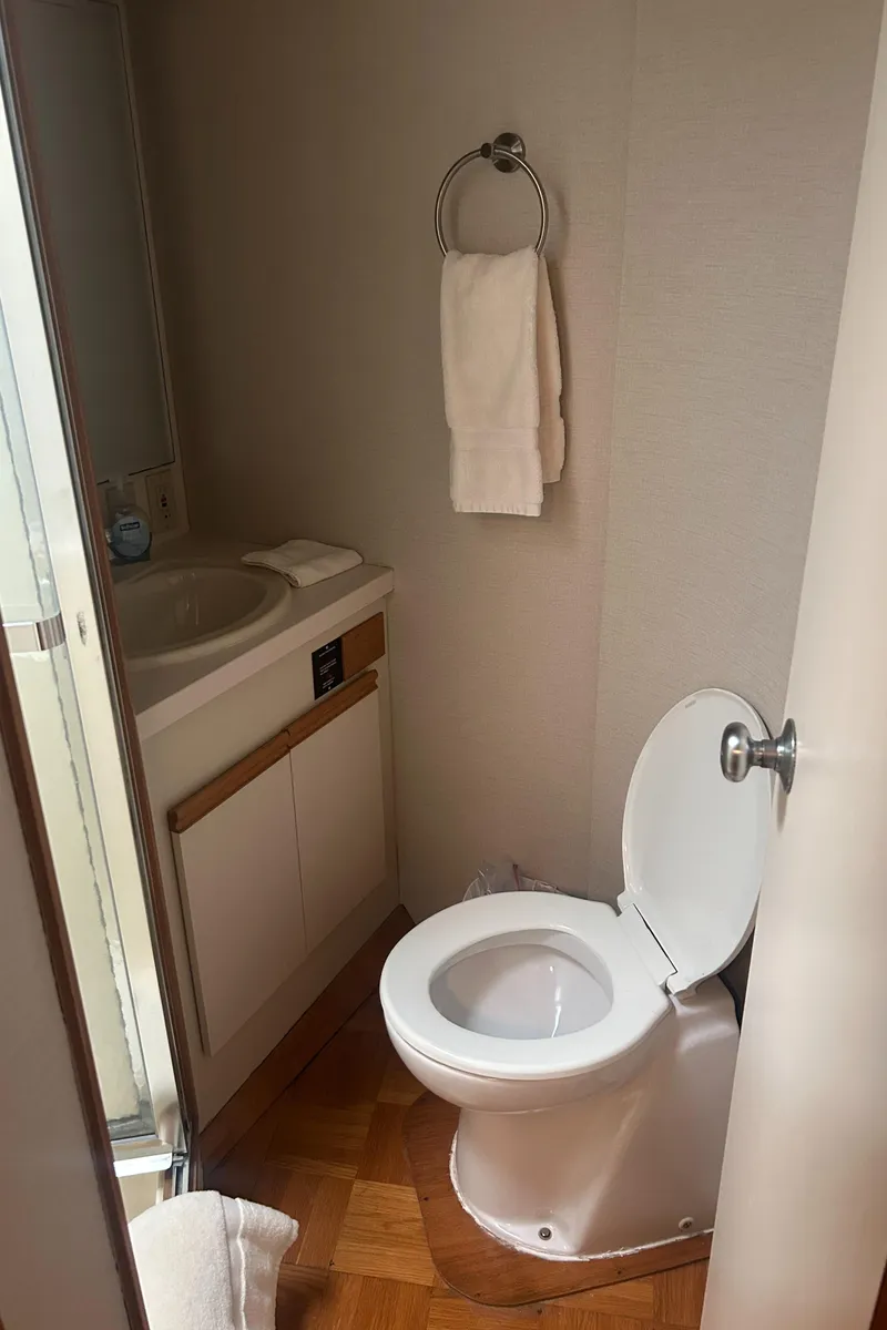 Slide: The Image of Bathroom interior of a 1990 Bertram 50 Convertible yacht, featuring a toilet and sink. - 35