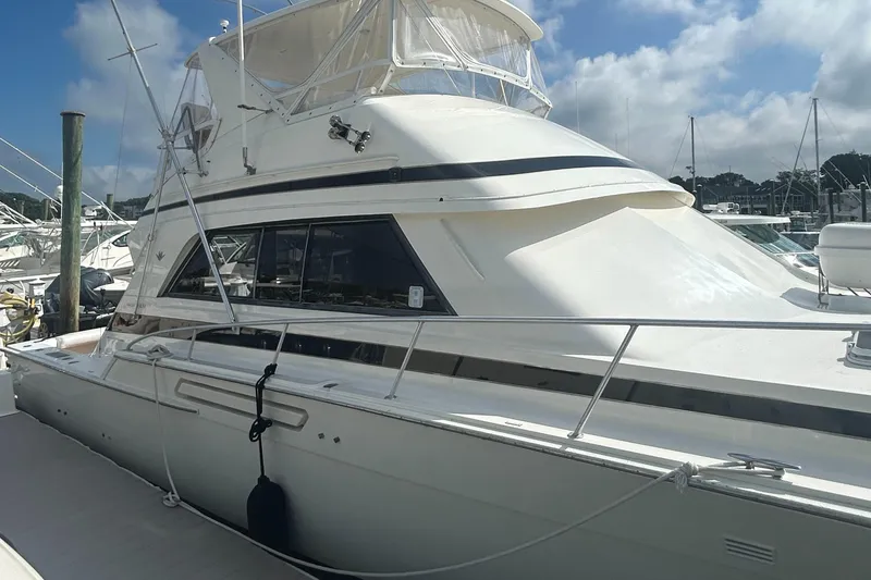 Slide: The Image of 1990 Bertram 50 Convertible yacht docked at marina under blue sky. - 36