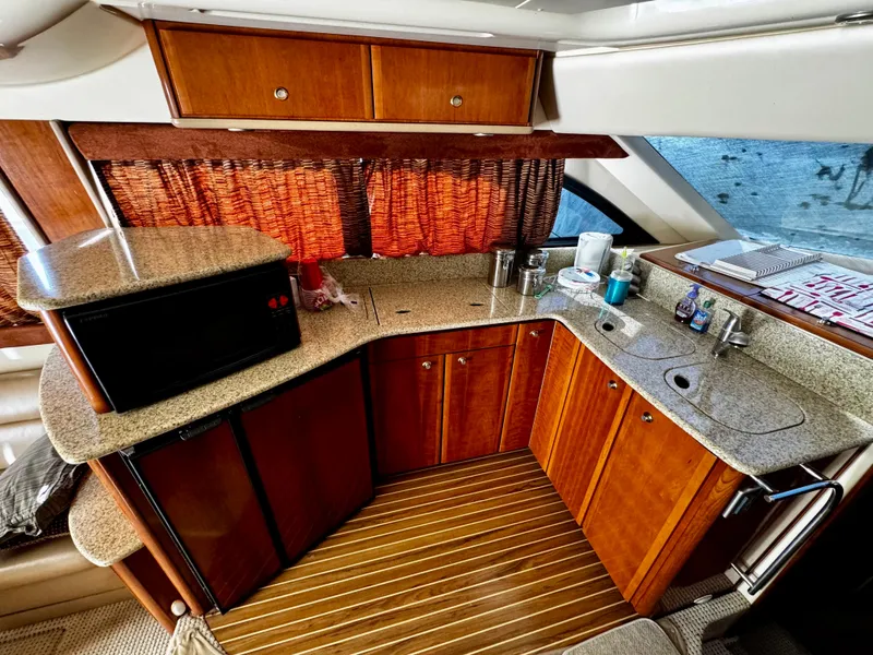 Slide: The Image of Luxurious kitchen area in a 2007 Meridian 411 Sedan yacht with wood cabinetry and granite countertops. - 12