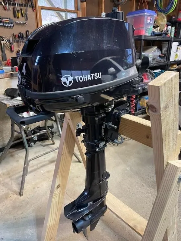 Slide: The Image of Tohatsu outboard motor in a workshop, mounted on a wooden stand. - 5