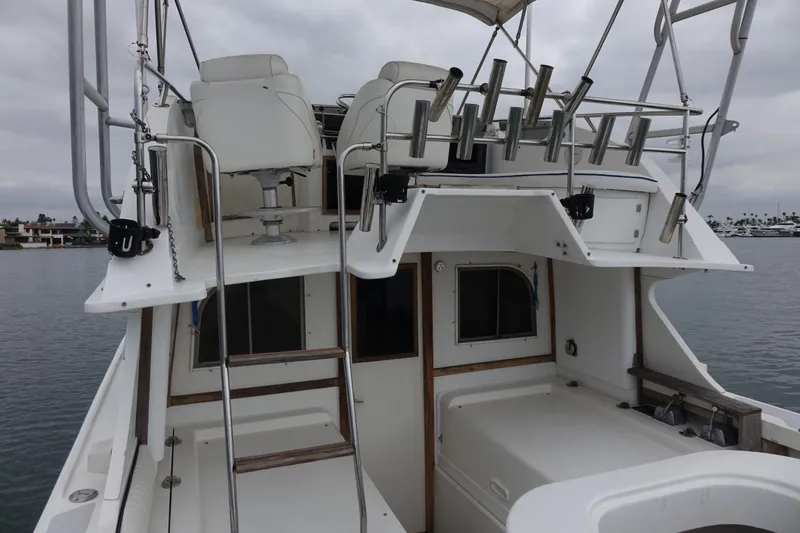 Slide: The Image of 1988 Blackfin 29 Flybridge boat with seating and rod holders, docked on a cloudy day. - 19