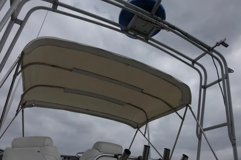 Slide: The Image of 1988 Blackfin 29 Flybridge boat canopy and seating under cloudy sky. - 20