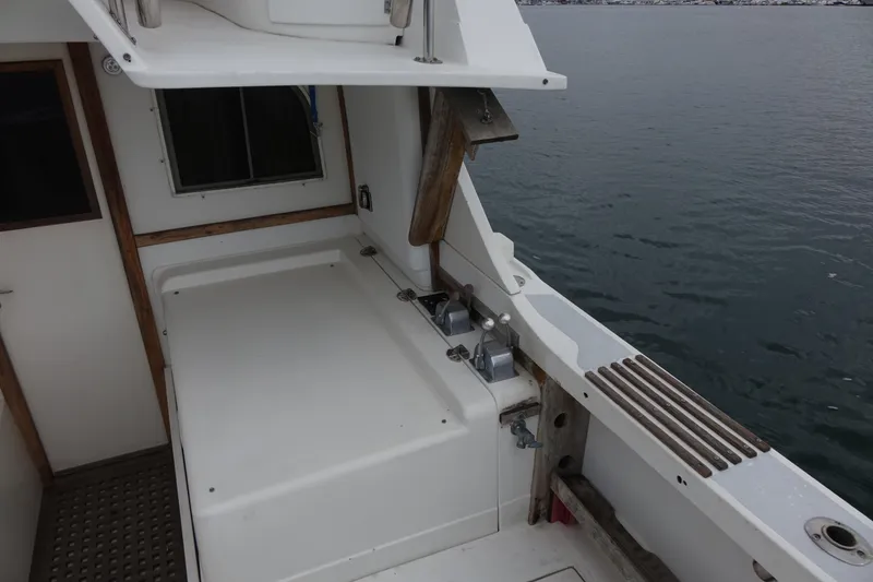 Slide: The Image of 1988 Blackfin 29 Flybridge boat deck with seating, overlooking calm water. - 22