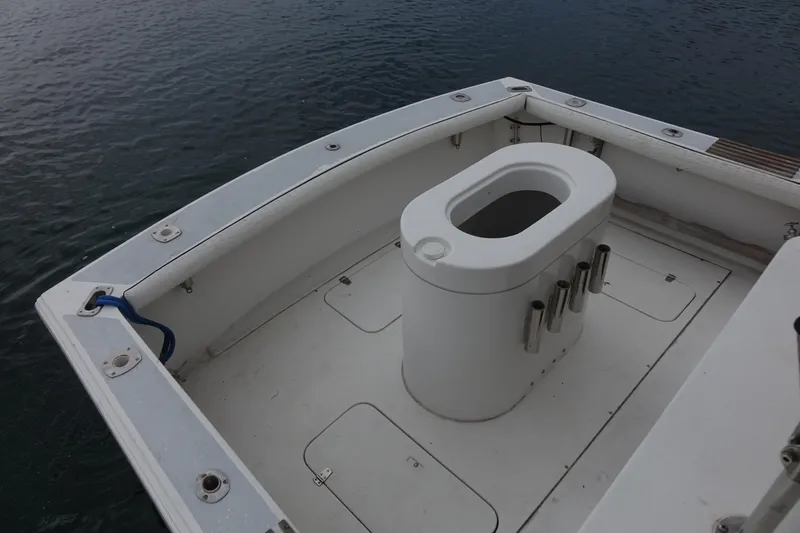 Slide: The Image of 1988 Blackfin 29 Flybridge boat deck with fishing rod holders, on calm water. - 27