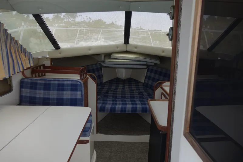 Slide: The Image of Interior of 1988 Blackfin 29 Flybridge with blue plaid seating and dining area. - 29