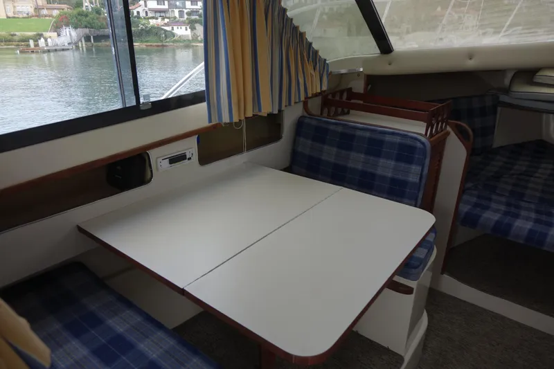 Slide: The Image of Interior of 1988 Blackfin 29 Flybridge with blue plaid seating and dining table. - 30