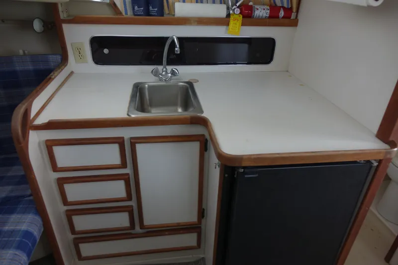 Slide: The Image of 1988 Blackfin 29 Flybridge kitchen with sink, counter, cabinets, and mini fridge. - 32