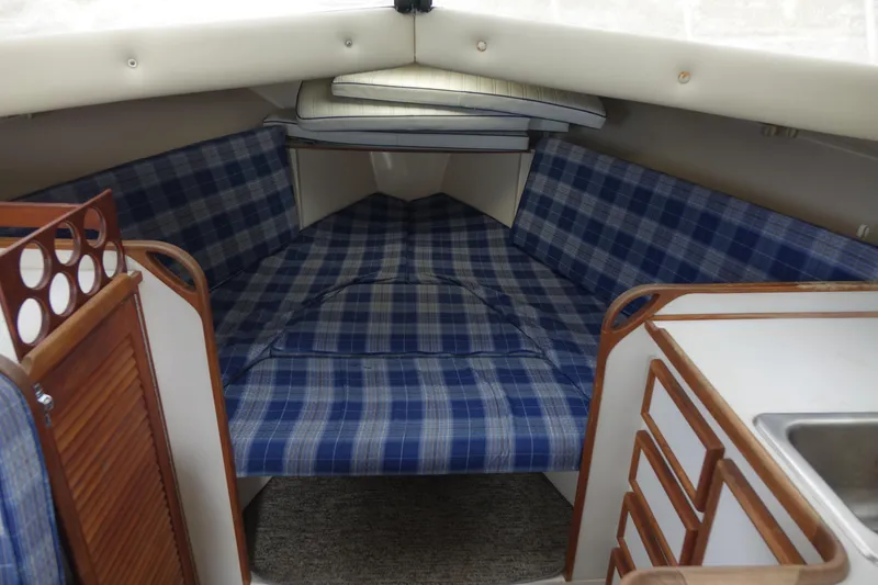 Slide: The Image of 1988 Blackfin 29 Flybridge cabin interior with blue plaid upholstery and wooden cabinetry. - 35