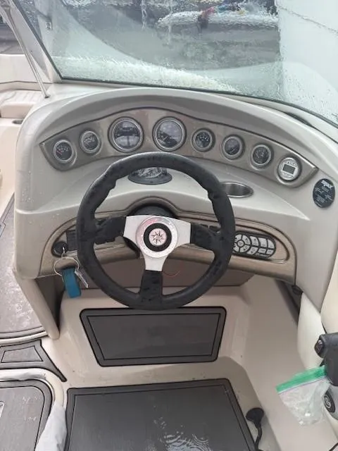 Slide: The Image of Steering wheel and dashboard of a 2006 Bryant 219 boat, featuring multiple gauges and controls. - 12