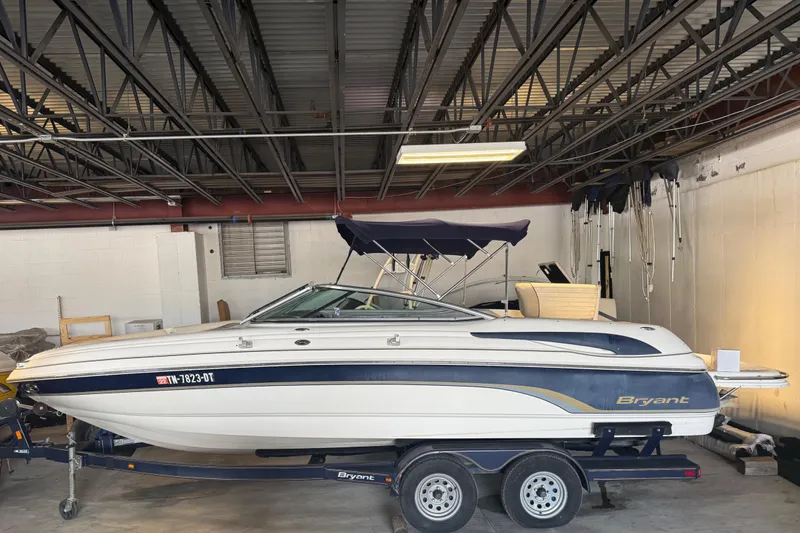 Slide: The Image of 2006 Bryant 219 boat in storage, featuring a sleek design and dual-axle trailer. - 3