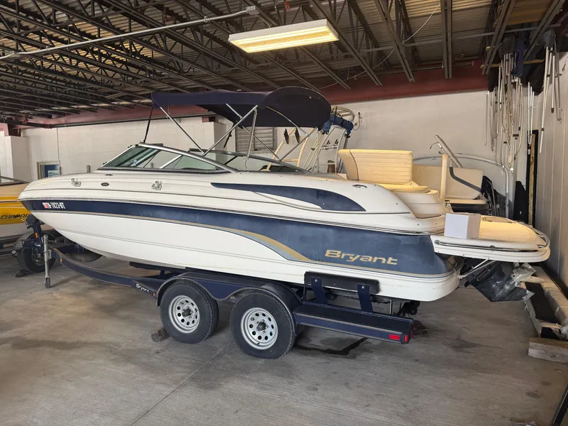 Slide: The Image of 2006 Bryant 219 boat in storage, featuring a sleek design and dual-axle trailer. - 4