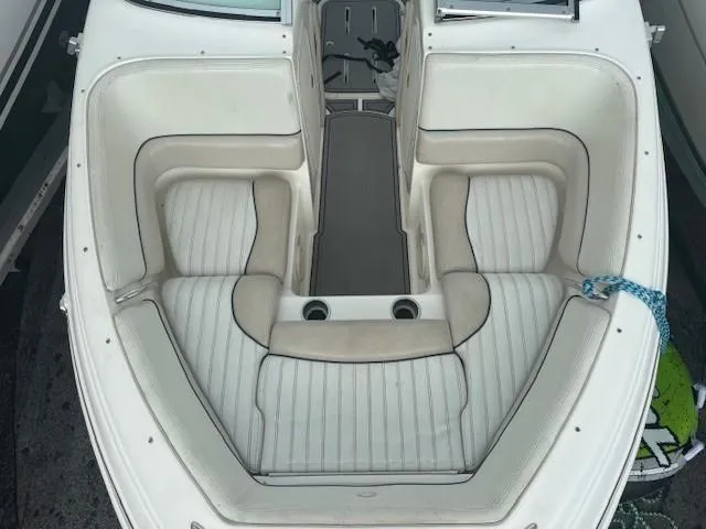 Slide: The Image of 2006 Bryant 219 boat interior with white cushioned seating and cup holders. - 7