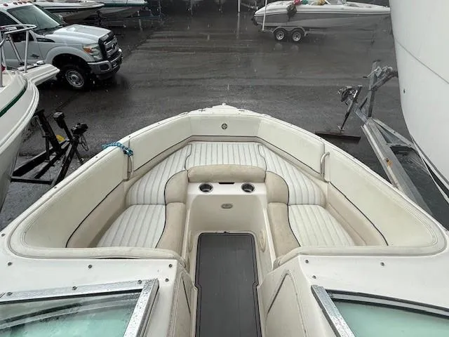 Slide: The Image of 2006 Bryant 219 boat interior with white seating, parked in a marina. - 8