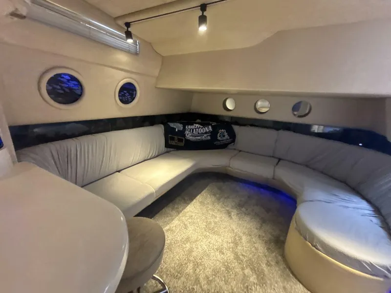 Slide: The Image of Luxurious interior of 1996 Sea Ray 500 Sundancer yacht with circular seating and porthole windows. - 10