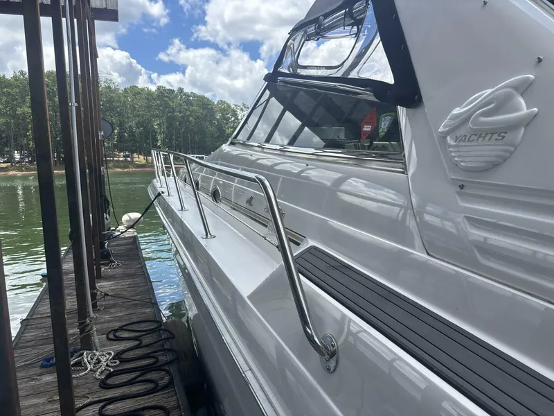 Slide: The Image of 1996 Sea Ray 500 Sundancer yacht docked by a serene lake. - 12