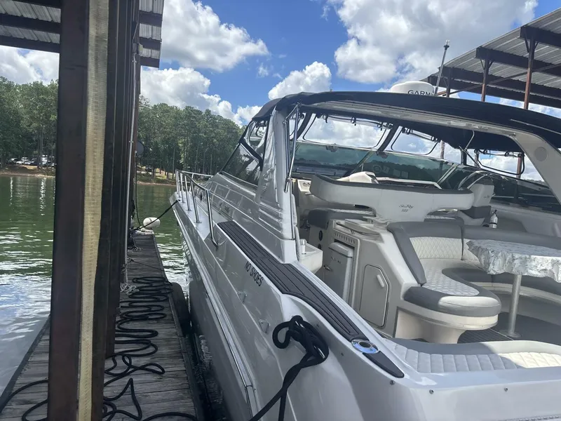 Slide: The Image of 1996 Sea Ray 500 Sundancer yacht docked, featuring spacious seating and sleek design. - 15