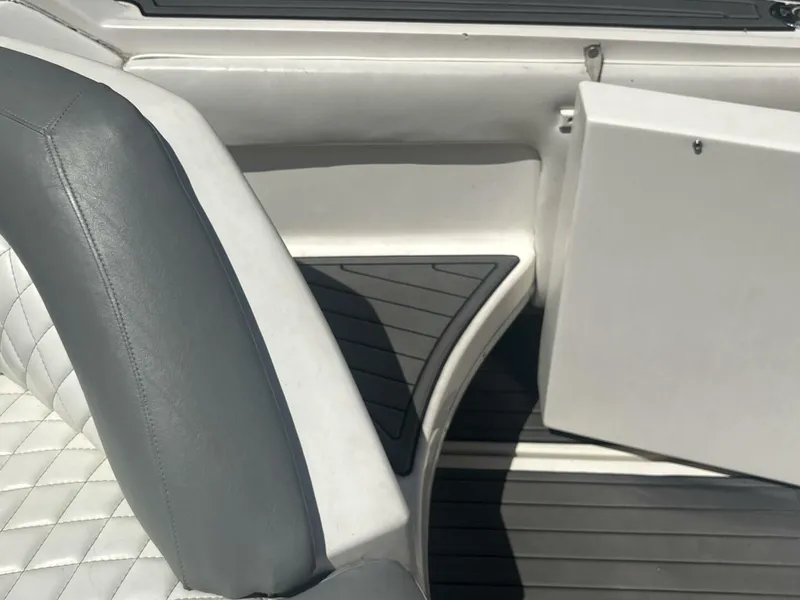 Slide: The Image of 1996 Sea Ray 500 Sundancer interior with gray and white seating and open storage compartment. - 23