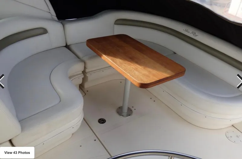 Slide: The Image of 2007 Sea Ray 340 boat interior with white seating and wooden table. - 9