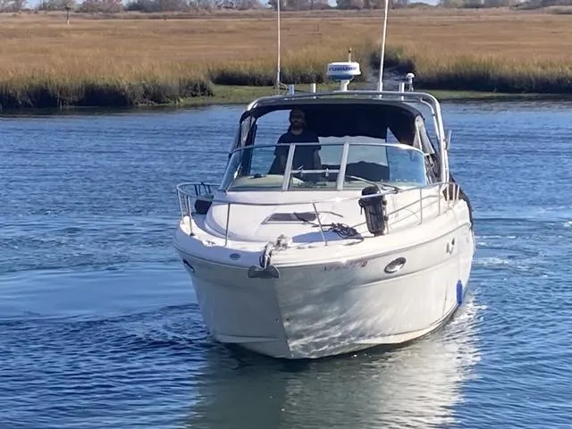 The Image of 2000 Sea Ray 290 Amberjack cruising on a calm river with grassy banks. - 0