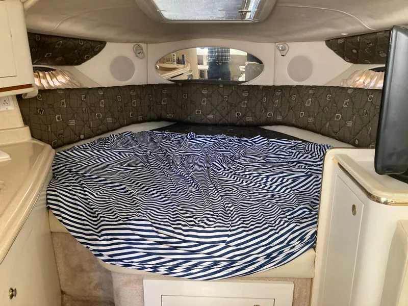 Slide: The Image of Interior cabin of 2000 Sea Ray 290 Amberjack with striped bedding. - 2