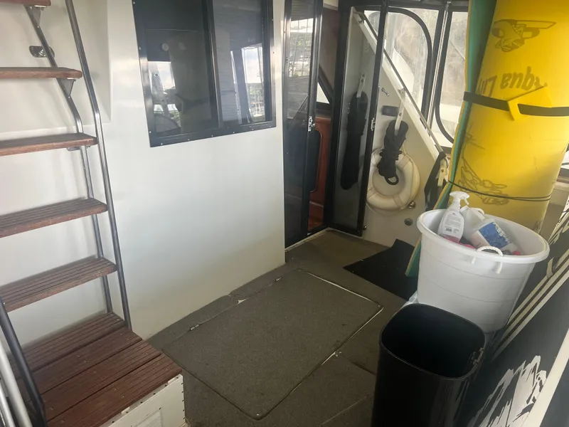 Slide: The Image of 1987 Carver 420 Cockpit Motor Yacht interior with stairs, cleaning supplies, and life preserver. - 11
