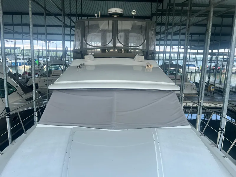 Slide: The Image of 1987 Carver 420 Cockpit Motor Yacht docked in a marina under a covered structure. - 15