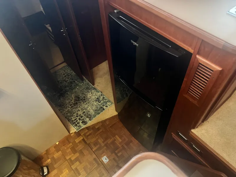 Slide: The Image of Interior of 1987 Carver 420 Cockpit Motor Yacht with wood flooring and compact kitchen. - 20